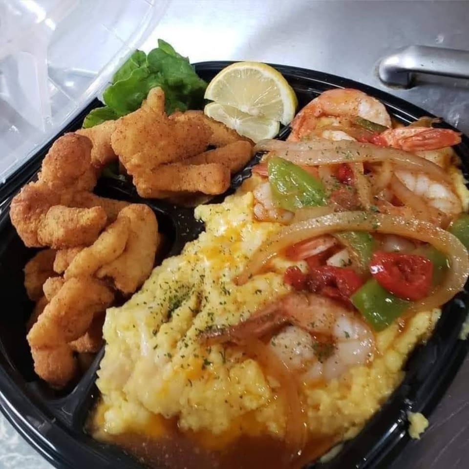 Shantell's soul food meal with fried fish, shrimp and grits, and a lemon wedge.