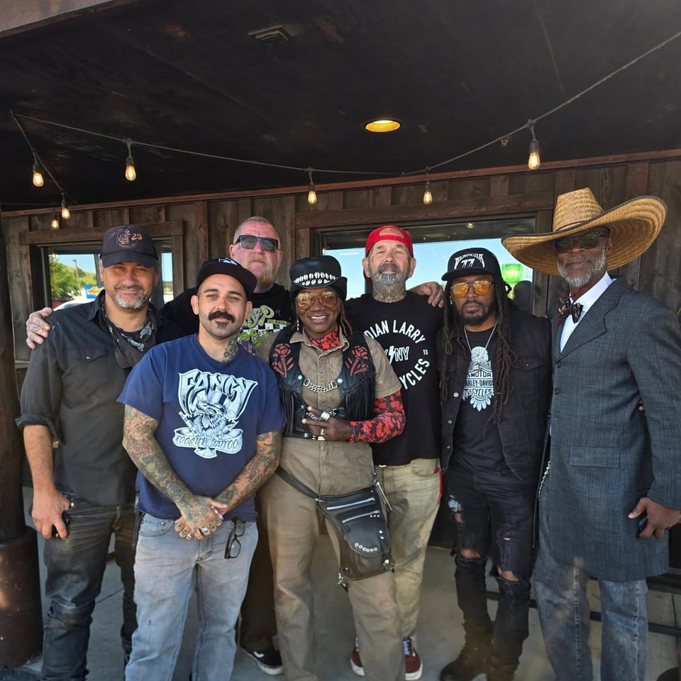 Seven people, including Shantell, pose together outside Shantell's Just Until Restaurant & Lounge.
