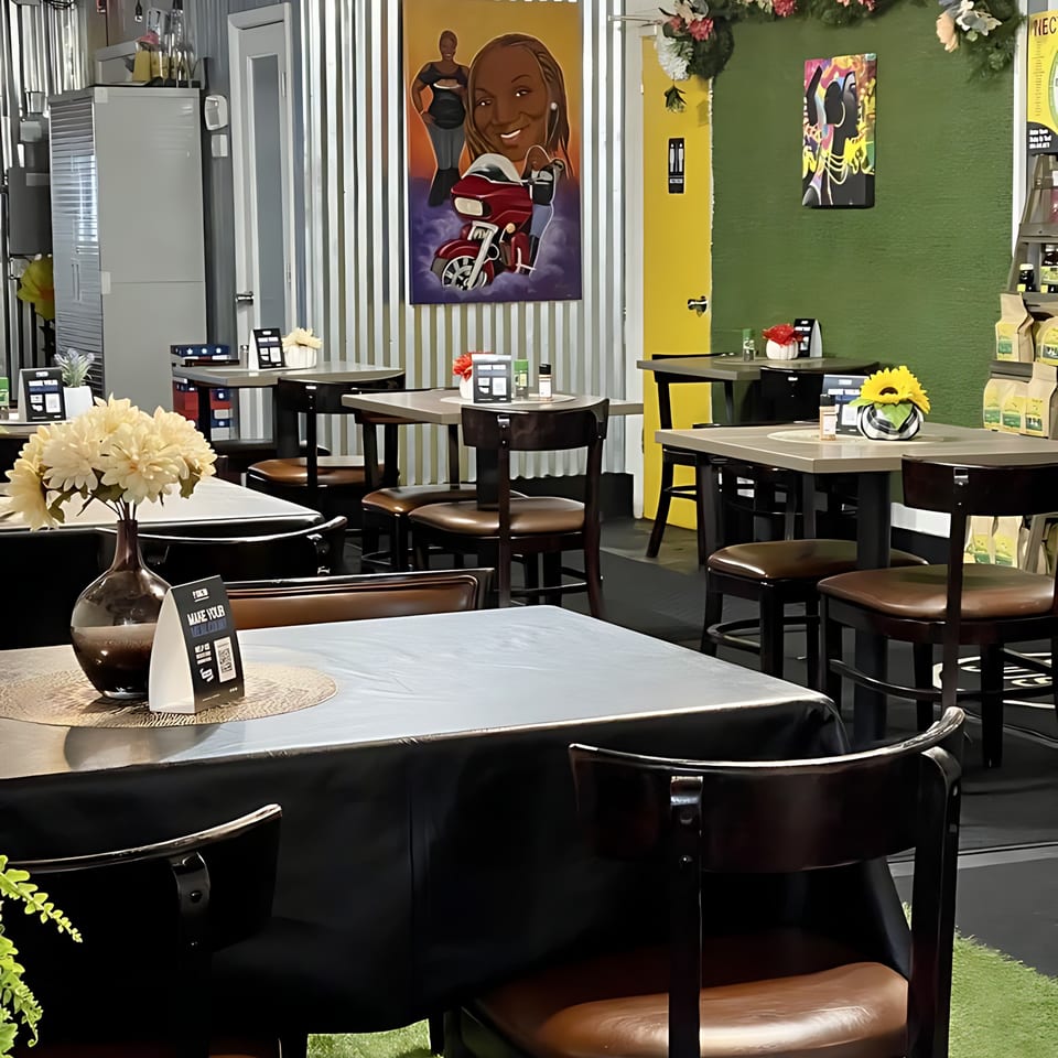 Interior of Shantell's Just Until Restaurant & Lounge, with tables, chairs, and vibrant wall decor.